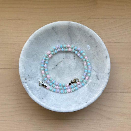 Beaded bracelet on a marble dish with a wooden background